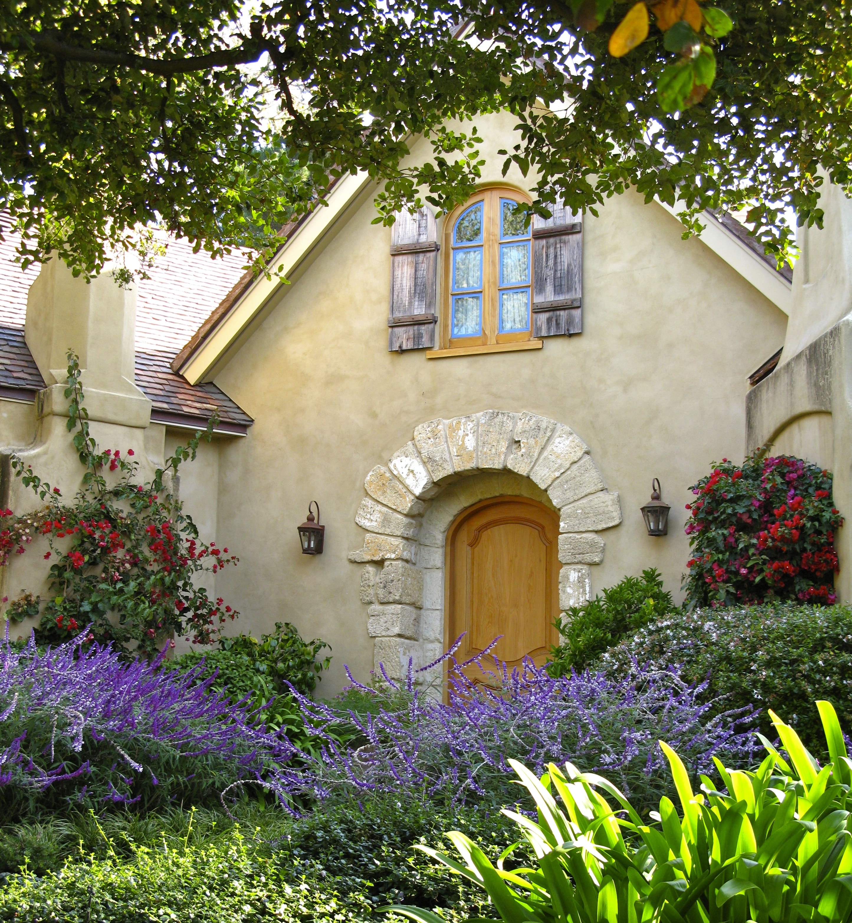 Charming home exterior with lush garden and arched doorway